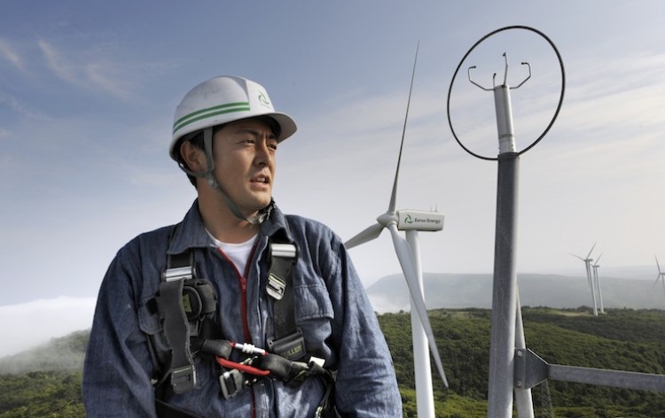 ON THE RISE: A chief mechanic of a wind-power farm in Japan works on top of a wind tower in Higashi-Dori in July 2008. With the nuclear disaster in Japan still unresolved, the country is now seeking to increase its renewable energy production to at least 20 percent.  (Kazuhiro Nogi/Getty Images)