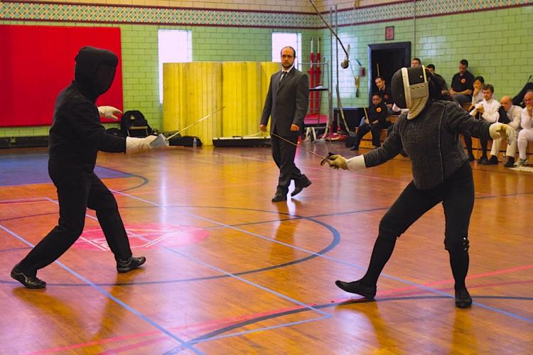 EN GARDE: Maestro Ramon Martinez (L) and Maestro Jeannette Acosta-Martinez (R) demonstrate classical French dagger fencing at the Thompson Athletic Center on Sunday. (Phoebe Zhang/The Epoch Times)