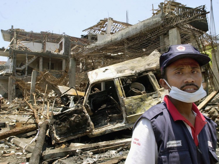 AUSTRALIANS HIT: An Indonesian Red Cross volunteer stands at the site of the car bombing in Kuta, Bali, Oct. 14, 2002. The Bali bombing was devastating, killing 200 people but has resulted in stronger ties between Australia and Indonesia. (Oka Budhi/Getty Images)