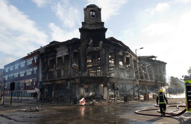 BURNED: Firefighters survey the burnt-out shell of a carpet showroom on High Road in Tottenham, North London, on Aug. 7.  (Leon Neal/AFP/Getty Images)