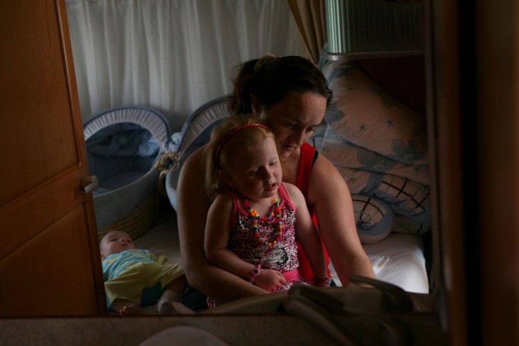 Jean Sheridan dresses her daughter Viviana at Dale Farm Travellers' site in Crays Hill, Essex. Also pictured is one of Jean's triplets Richard in this photo from 2009. (Courtesy of Mary Turner)