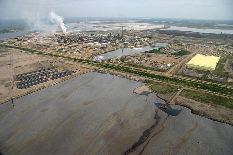 Tailings ponds near Syncrude's processing facilities in northern Alberta. Green groups allege that the government is failing to enforce its own anti-pollution provisions under the federal Fisheries Act by allowing oil sands tailings ponds to leak into groundwater. (David Dodge, The Pembina Institute www.OilSandsWatch.org)