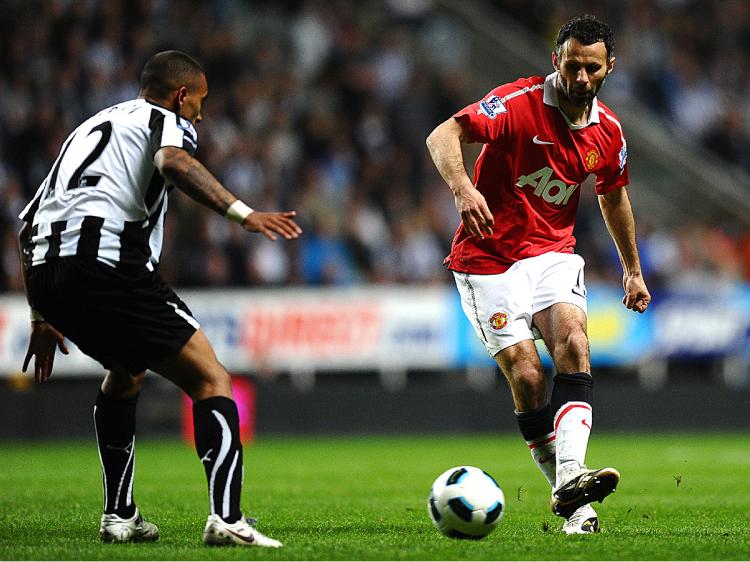 Manchester United's Welsh midfielder Ryan Giggs (R) shoots past Newcastle United's English defender Danny Simpson during the English Premier League football match between Newcastle United and Manchester United at St James' Park. (Paul Ellis/AFP/Getty Images)