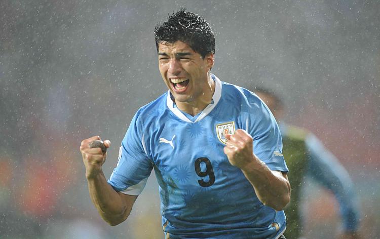 Luis Suarez celebrates his second goal in a driving rainstorm. (Rodrigo Arangua/AFP/Getty Images)