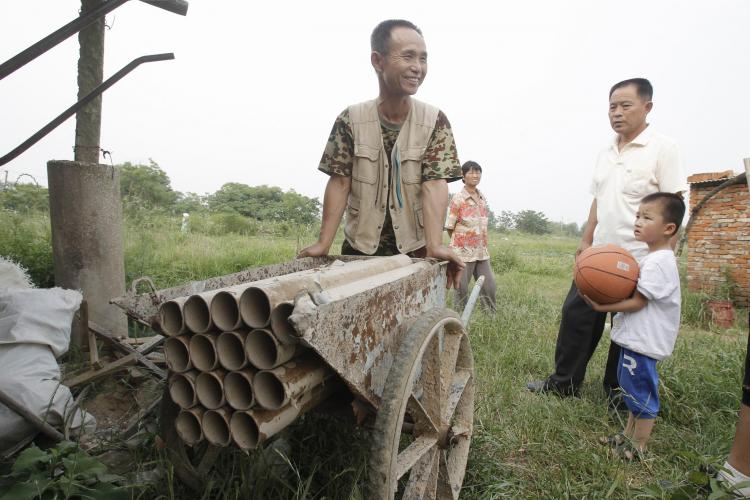 Yang Youde wheels his homemade cannons around his property on June 6. (Epoch Times Archive)