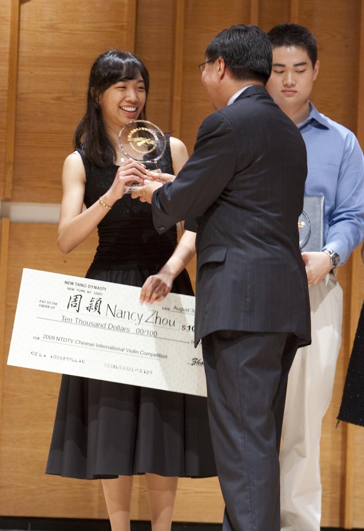 NTDTV President John Tang presents gold medalist Nancy Zhou with a check for $10,000.  (Edward Dai/The Epoch Times)