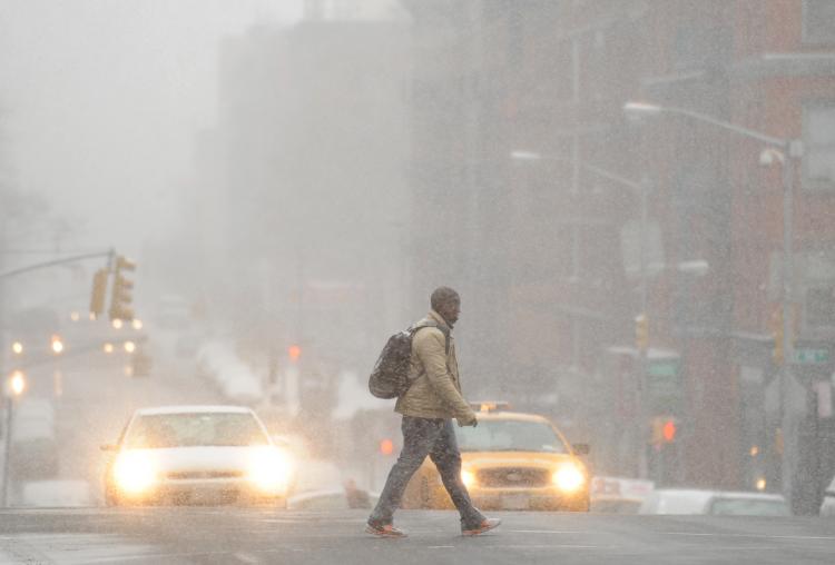 A man crosses Lexington Avenue on the east side of Manhattan as snow falls Dec. 26 in New York. (Stan Honda/AFP/Getty Images)