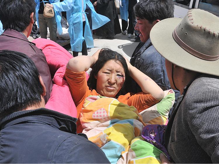 Residents carry an injured survivor who was rescued from the rubble of a collapsed building on April 15, 2010 after a 6.9-magnitude earthquake hit Yushu county in northwest China's Qinghai province on April 14. (AFP/Getty Images)