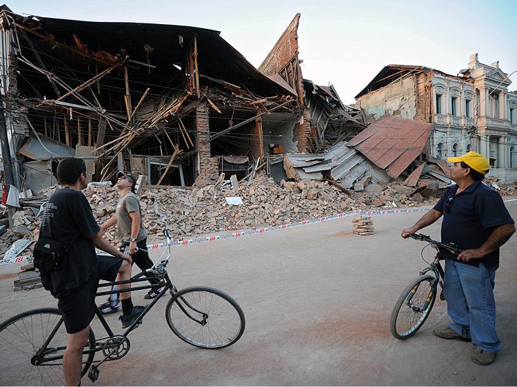 Men observe a destroyed building in Curico, 250 km south of Santiago, after an 8.8-magnitude earthquake struck Chile. Aftershocks were felt as far away as Argentina. (Martin Bernetti/AFP/Getty Images)