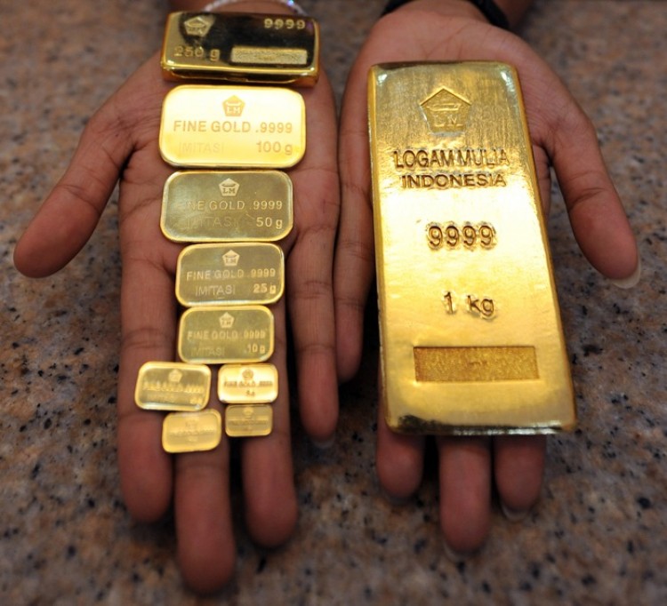 COUNTRY COLLATERAL: An Indonesian employee holds ingots of gold at the marketing office of PT. Antam Tbk during trade in Jakarta in this file photo. East Asia, the Indian subcontinent, and the Middle East combined consume 70 percent of the worlds gold supply. (Adek Berry/AFP/Getty Images)