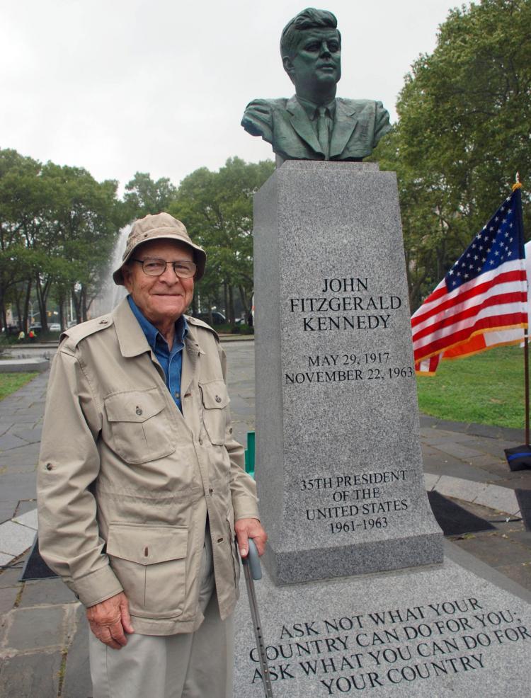 Sculptor Neil Estern poses beside his memorial bust of late President John F. Kennedy at Prospect Park in Brooklyn (Helena Zhu/The Epoch Times)