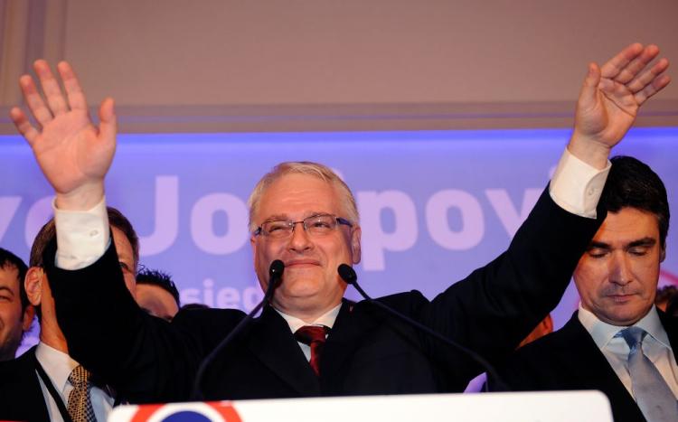 Main Social Democratic Party's presidential candidate Ivo Josipovic raises his hand after hearing first preliminary results of the Croatian presidential elections in his headquarters, in Zagreb on Jan. 10, 2010. (Hrvoje Polan/AFP/Getty Images)