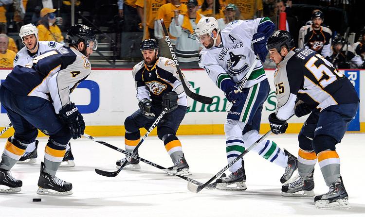 Ryan Kessler #17 of the Vancouver Canucks breaks a stick while dumping the puck past Shane O'Brien #55 and Steve Sullivan #26 of the Nashville Predators in Game Three of the Western Conference Semifinals during the 2011 NHL Stanley Cup Playoffs. (Frederick Breedon/Getty Images)