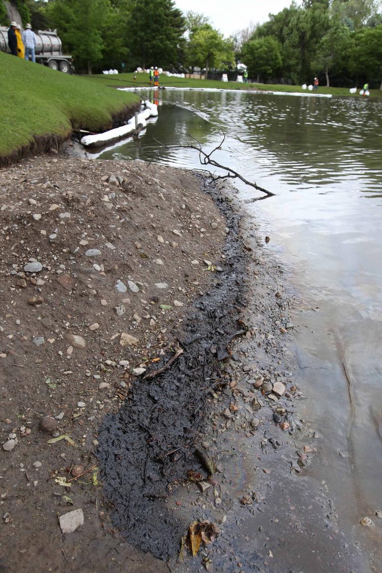 Oil sits on the shores as hazardous material clean up works lay boom in a pond in Liberty Park June 12, in Salt Lake City, Utah. The oil pipe owned by Chevron Oil Company broke several miles upstream and spewed out a significant amount of oil.  (George Frey/Getty Images)