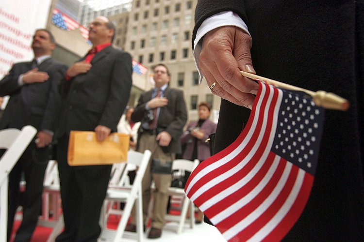 Attendees stand for the Pledge of Allegiance