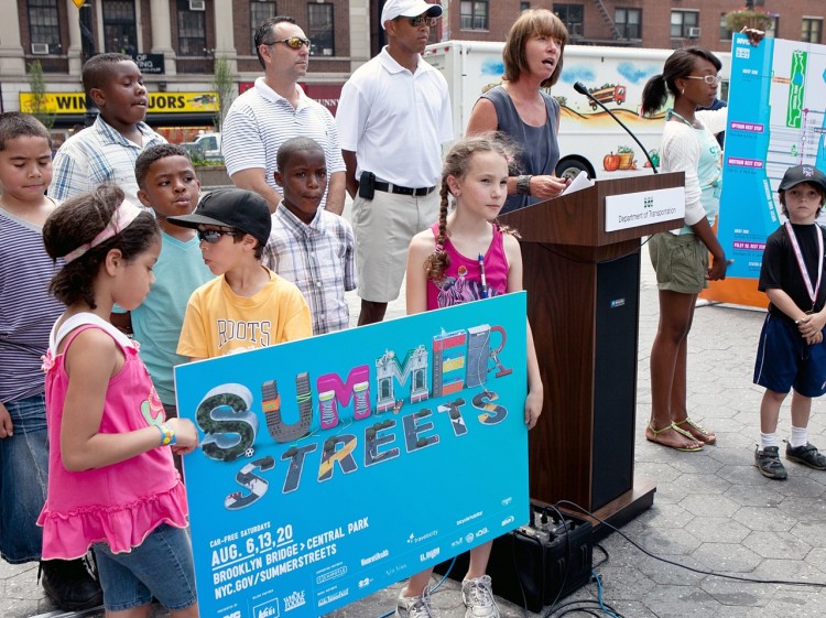 SUMMER STREETS: Young children hold a sign for the Summer Streets initiative, while Department of Commissioner Janette Sadik-Khan speaks and former sports stars John Starks and John Franco look on. (Amal Chen/The Epoch Times)