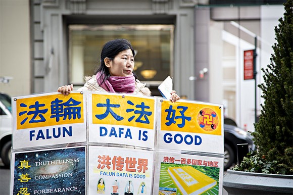 Wang Huijuan, em frente ao Empire State Building, em Manhattan, Nova York, em 12 de janeiro de 2017, realiza uma exposição para ajudar os turistas chineses a entender os fatos sobre a perseguição ao Falun Gong na China (Samira Bouaou / Epoch Times)