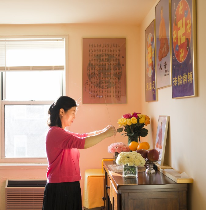 Wang Huijuan presta seus respeitos ao fundador do Falun Gong em sua casa em Queens, Nova York, em 8 de janeiro de 2016. Com o marido e a filha, ela escapou da China em 2014 e recebeu asilo após anos de tortura por praticar o Falun Gong  (Samira Bouaou / Epoch Times)