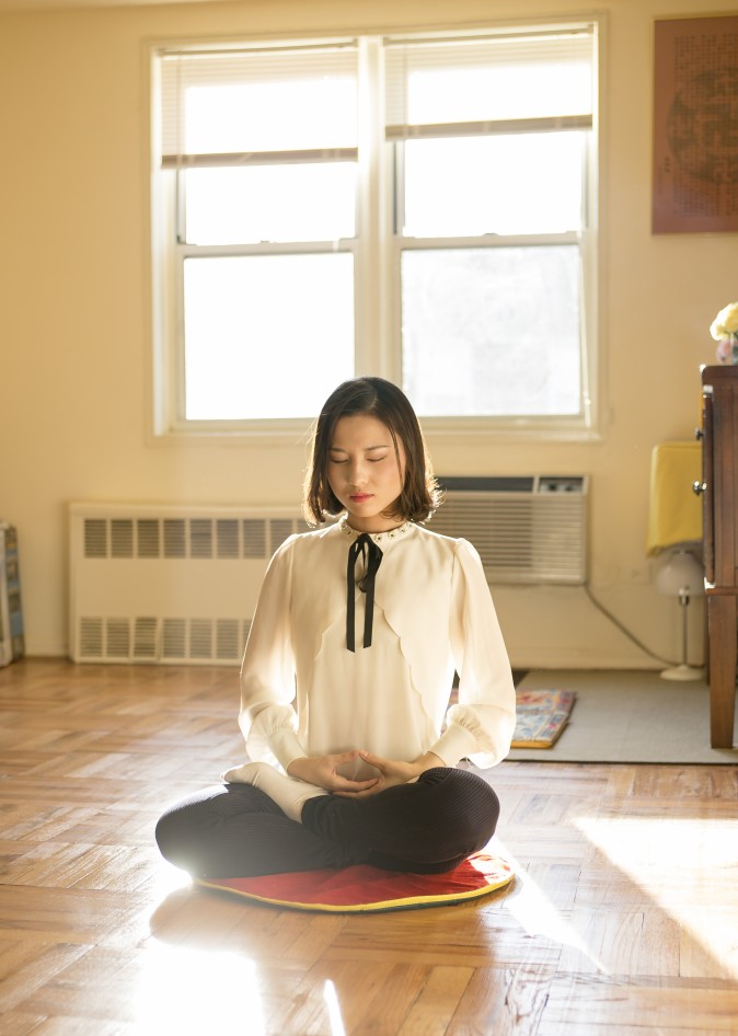  Li Fuyao demonstra sua prática de meditação em sua casa em Queens, Nova York, em 8 de janeiro de 2016. Ela e seus pais escaparam da China em 2014 e receberam asilo após anos de tortura por praticar o Falun Gong (Samira Bouaou / Epoch Times)