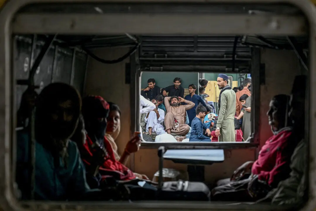 People wait for a train to depart at a railway station in Karachi, Pakistan, on March 18, 2026, as they head to their hometowns for the upcoming Eid al-Fitr festivities. (Rizwan Tabassum / AFP via Getty Images)