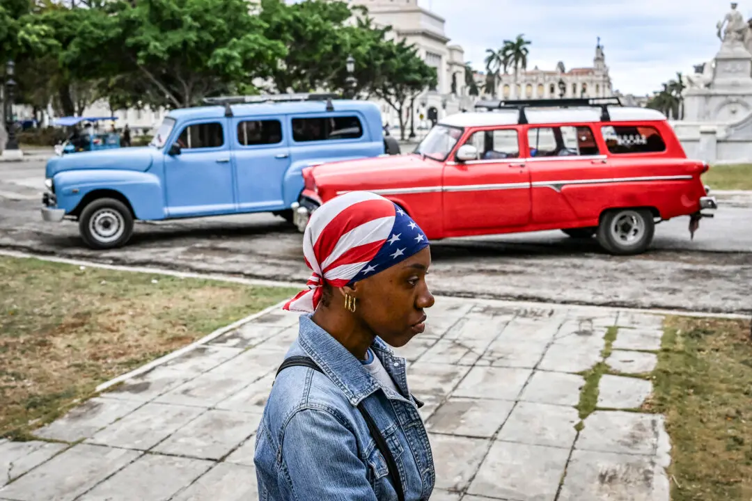 A woman wearing a headscarf with the US flag walks down a street in Havana on March 19, 2026. (Photo by YAMIL LAGE / AFP via Getty Images)
