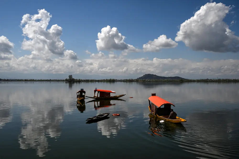 Kashmiri boatmen row their shikara boats in Dal Lake in Srinagar, India, on March 16, 2026. (Tauseef Mustafa/ AFP via Getty Images)