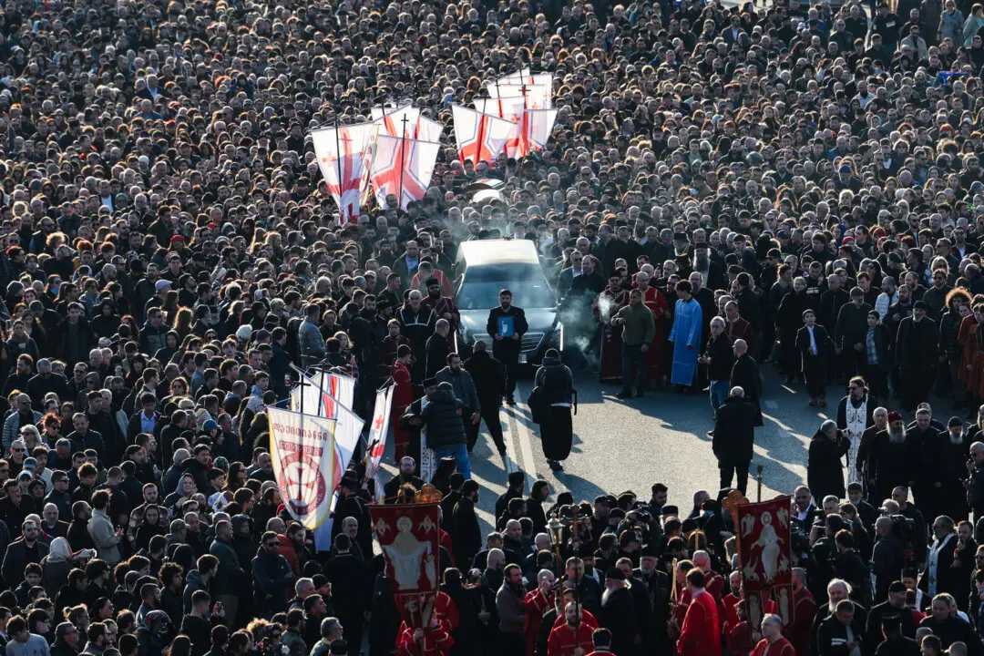 Mourners follow the hearse transporting the coffin with the body of the late Georgia's Orthodox Patriarch Ilia II prior to a memorial service to be held at the Sameba Cathedral in Tbilisi, Georgia, on March 18, 2026. Georgian Orthodox Church leader Ilia II died on March 17, 2026 aged 93, the church said, after nearly half a century at the helm of one of the country's most powerful institutions. (Giorgi Arjevanidze / AFP via Getty Images)